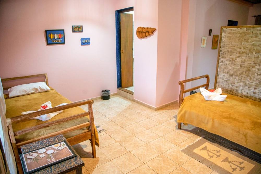 Quarto do espaço com camas e mobiliário em madeira
